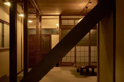 a staircase in a room with a cat sitting on the floor at Rojiura in Tokyo