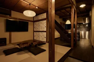 a living room with a tv and a staircase at Rojiura in Tokyo