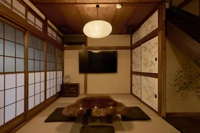 a room with a table and a flat screen tv at Rojiura in Tokyo