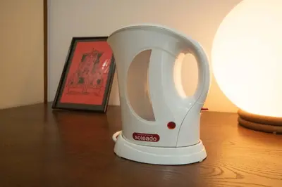 a white appliance sitting on a table next to a picture at \u30c8\u30a6\u30bb\u30f3\u30cf\u30a4\u30c4 in Tokyo