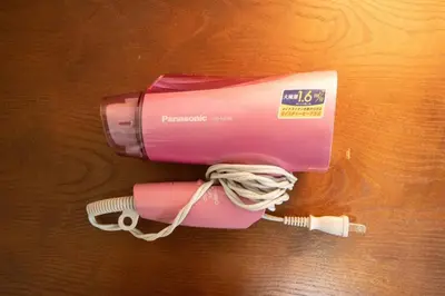 a pink hair dryer sitting on top of a table at \u30c8\u30a6\u30bb\u30f3\u30cf\u30a4\u30c4 in Tokyo