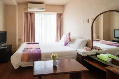 a hotel room with two beds and a mirror at \u4e09\u30ce\u8f2a \u5409\u539f in Tokyo