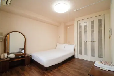 a bedroom with a white bed and a mirror at \u4e09\u30ce\u8f2a \u5409\u539f in Tokyo