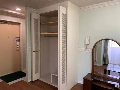 a room with a closet with a mirror and a mirror at \u4e09\u30ce\u8f2a \u5409\u539f in Tokyo