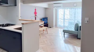 a kitchen and a living room with a table and a couch at Shinjuku Kabukicho#\u65b0\u5bbf\u6b4c\u821e\u4f0e\u753a \u5730\u94c1\u6b65\u884c3\u5206#2\u5367\u5ba4\u65b0\u88c5\u4fee#\u9ad8\u901f\u7f51\u7edc#\u667a\u80fd\u9a6c\u6876#\u5e72\u6e7f\u5206\u79bb1001 in Tokyo