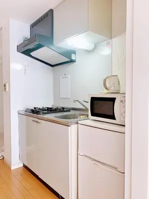 a white kitchen with a microwave and a stove at Ikebukuro Center! Ikebukuro 6min walk! \u6c60\u888b\u4e2d\u5fc3\u5730\u5e26! \u6c60\u888b\u8f66\u7ad9\u6b65\u884c6\u5206! \u516c\u5bd3\u5e72\u6e7f\u5206\u79bb! \u667a\u80fd\u9a6c\u6876! \u9ad8\u901f\u65e0\u9650\u5236\u7f51\u8def!Autolock302 in Tokyo