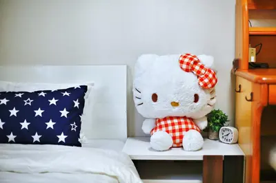 a stuffed teddy bear sitting on a table next to a bed at \u30a2\u30ad\u30e9\u5546\u4e8b in Tokyo