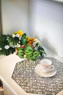 a cup and a plate on a table with flowers at \u30a2\u30ad\u30e9\u5546\u4e8b in Tokyo