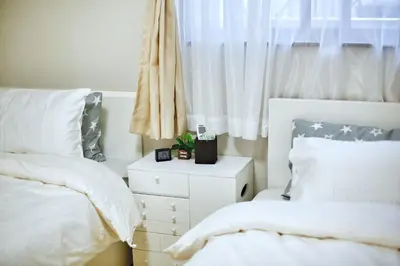 a white bedroom with two beds and a window at \u30a2\u30ad\u30e9\u5546\u4e8b in Tokyo