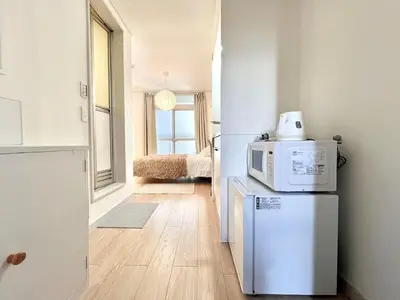 a kitchen with a microwave on top of a refrigerator at Shinjuku YC Hostel-SJ0399 in Tokyo