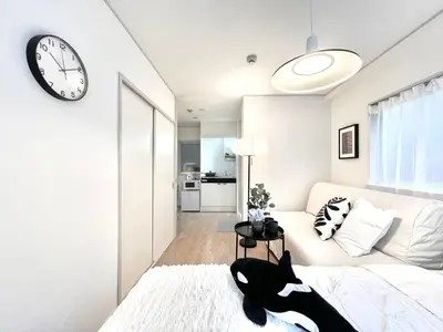a white living room with a clock on the wall at Shinjuku YC Hostel-SJ0399 in Tokyo
