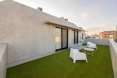 a balcony with chairs and a table and grass at 67 Apt Nishishinjuku Premium in Tokyo