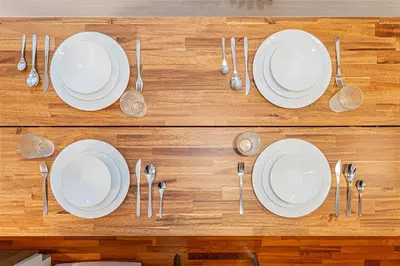 a wooden table with white plates and spoons at 67 Apt Nishishinjuku Premium in Tokyo