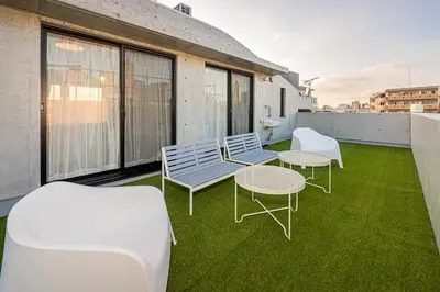 a balcony with chairs and tables on a roof at 67 Apt Nishishinjuku Premium in Tokyo