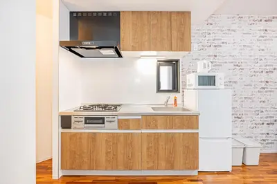 a kitchen with a stove and a refrigerator at 67 Apt Nishishinjuku Premium in Tokyo