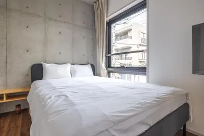 a bedroom with a large white bed and a window at 67 Apt Kagurazaka Premium in Tokyo