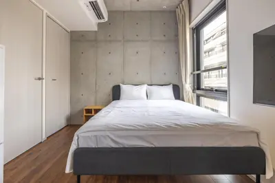 a bedroom with a large bed and a window at 67 Apt Kagurazaka Premium in Tokyo