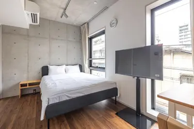 a bedroom with a bed and a flat screen tv at 67 Apt Kagurazaka Premium in Tokyo