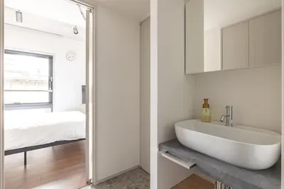 a white bathroom with a sink and a bed at 67 Apt Kagurazaka Premium in Tokyo