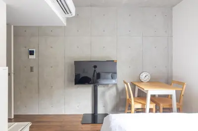 a room with a table and a tv on a wall at 67 Apt Kagurazaka Premium in Tokyo