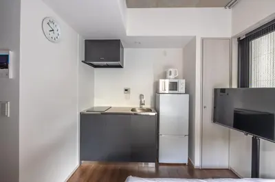 a small kitchen with a refrigerator and a microwave at 67 Apt Kagurazaka Premium in Tokyo
