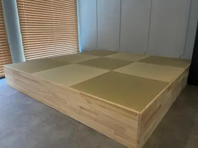 a large wooden bed in a room with a window at Tatami-Tokyo studio apartment in Tokyo