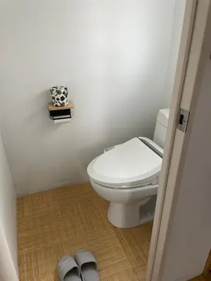a bathroom with a toilet and a book and slippers at Tatami-Tokyo studio apartment in Tokyo