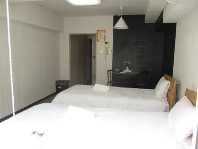 a bedroom with two white beds and a table at \u30e9\u30a4\u30aa\u30f3\u30ba\u30de\u30f3\u30b7\u30e7\u30f3\u9053\u7384\u5742\uff42 in Tokyo