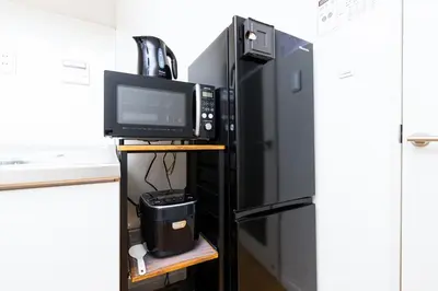 a kitchen with a microwave and a refrigerator at Zen Home AKABANE in Tokyo