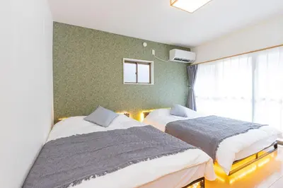 a bedroom with two beds and a window at Zen Home AKABANE in Tokyo