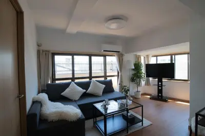 a living room with a blue couch and a tv at Shibuya Center Street 4 minutes direct access to Shinjuku and Harajuku and Omotesando in Tokyo