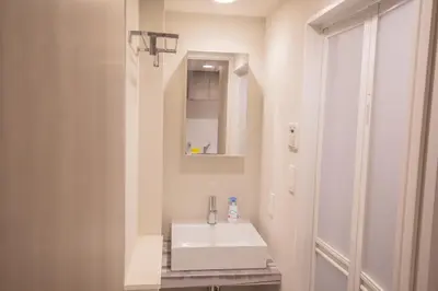 a bathroom with a white sink and a mirror at Central Yoyogi Guesthouse Y0YG in Tokyo