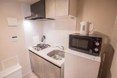 a small kitchen with a sink and a microwave at Central Yoyogi Guesthouse Y0YG in Tokyo