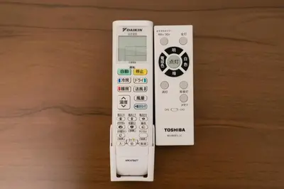 a remote control sitting on top of a wooden table at \u9326\u7cf8\u753a in Tokyo