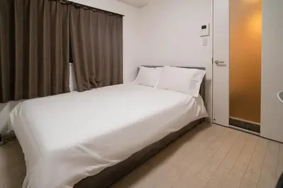 a large white bed in a room with a window at \u9326\u7cf8\u753a in Tokyo
