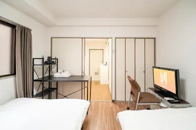 a bedroom with a tv and a desk with a chair at \u9326\u7cf8\u753a in Tokyo