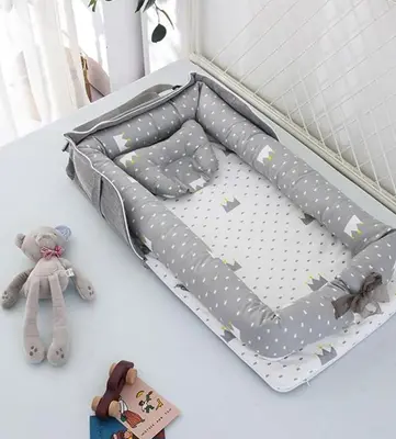 a bed with a comforter with stars and a teddy bear at TRILOOP Higashi-Shinjuku in Tokyo