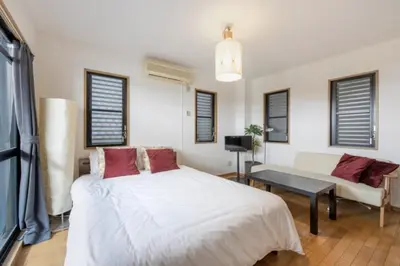 a bedroom with a white bed and a couch at TRILOOP Higashi-Shinjuku in Tokyo