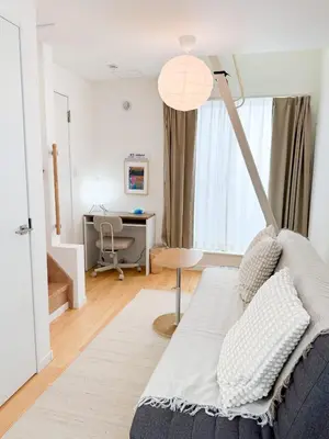 a living room with a bed and a desk at Triphome Shinjuku Takadanobaba Sakura House in Tokyo