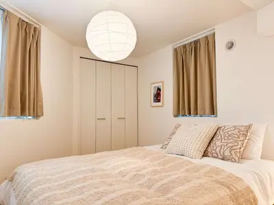 a bedroom with a bed and a pendant light at Triphome Shinjuku Takadanobaba Sakura House in Tokyo