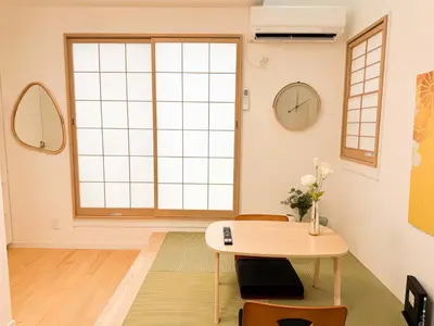 a living room with a table and a large window at Triphome Shinjuku Takadanobaba Sakura House in Tokyo