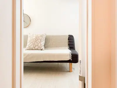 a couch in a living room with a pillow on it at Triphome Shinjuku Takadanobaba Sakura House in Tokyo