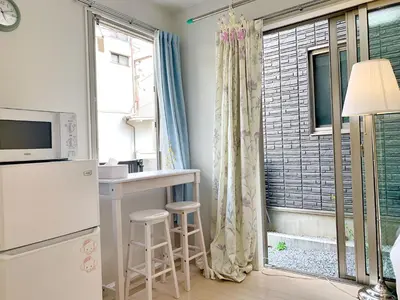 a kitchen with a refrigerator and a table and a window at JR t akadababa subway 5 mins walk! Newly building \u65b0\u7bc9! \u9ad8\u7530\u99ac\u5834\u99c5 \u5f92\u6b69\u570f\u5185\u5927\u4eba\u6c17! Shinjuku\u65b0\u5bbf\u5708!\u9ad8\u901f\u65e0\u9650\u5236Wi-FI BC in Tokyo