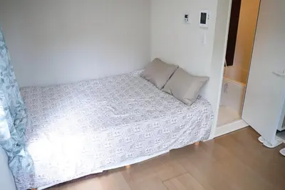 a small bed in a small room with a pillow at JR t akadababa subway 5 mins walk! Newly building \u65b0\u7bc9! \u9ad8\u7530\u99ac\u5834\u99c5 \u5f92\u6b69\u570f\u5185\u5927\u4eba\u6c17! Shinjuku\u65b0\u5bbf\u5708!\u9ad8\u901f\u65e0\u9650\u5236Wi-FI BC in Tokyo