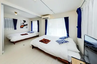 a bedroom with two beds and a flat screen tv at Gran Duo Shirokane by Tranova in Tokyo