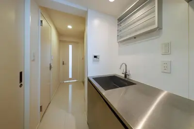 a kitchen with a stainless steel sink and a hallway at Gran Duo Shirokane by Tranova in Tokyo
