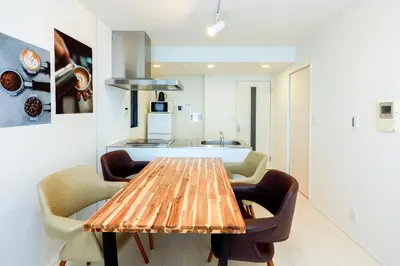 a dining room table with chairs and a kitchen at Gran Duo Shirokane by Tranova in Tokyo