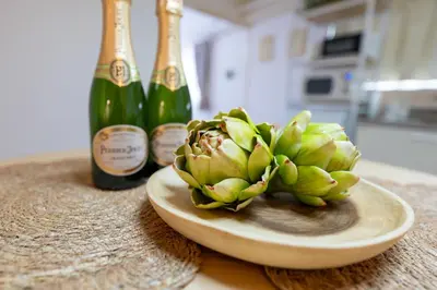 a bunch of green bananas on a plate next to a bottle of champagne at Beige2nd in Tokyo