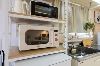 a microwave on a shelf in a kitchen at Beige2nd in Tokyo