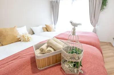 a bird cage sitting on a bed with towels at Beige2nd in Tokyo